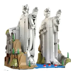 Bring the majesty of Middle-earth directly to your bookshelf with this 867-piece King's Book Nook Argonath building set by DK (Set #6037 / #6038). Recreating the iconic Gates of Argonath, this intricate bookshelf diorama features the monumental stone statues of Isildur and Anárion with outstretched hands warning travelers entering Gondor's northern border. The two towering colossi flank a translucent blue river path detailed with rocky cliffs, riverbank moss, and miniature pine trees. The frame opens or slides into bookshelf rows, creating a glowing 3D depth effect enhanced by integrated light brick elements. Completing this cinematic Middle-earth display are 3 exclusive Brickfigures: Aragorn, Boromir, and Frodo Baggins in his Elven cloak.